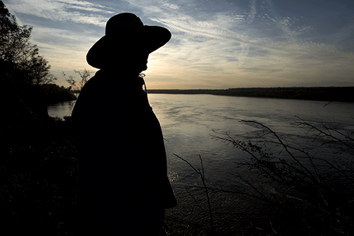 silhouette of man looking over Mississippi River