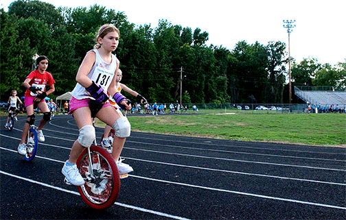A unicyclist girl is determined to keep her lead.