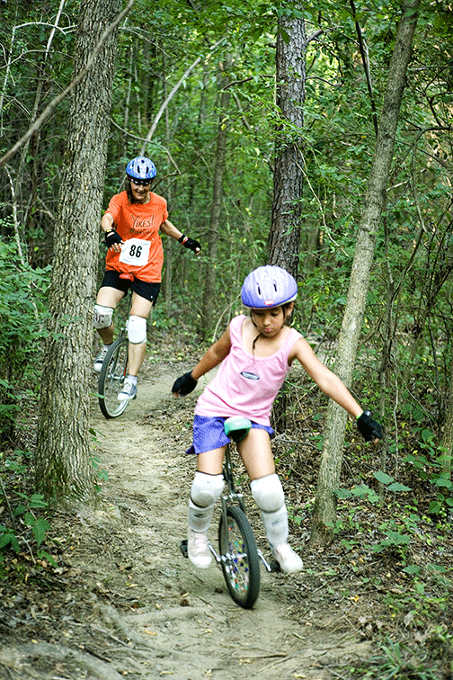 Mom and Daughter enjoy unicycling thru woods