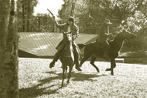 photo of two actors firing guns on horses