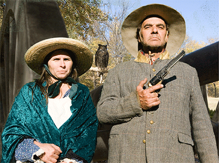 Picture of woman, man with gun with canon and owl in background